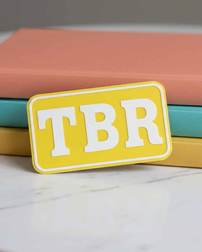 Yellow 'TBR' patch on a textured gray surface